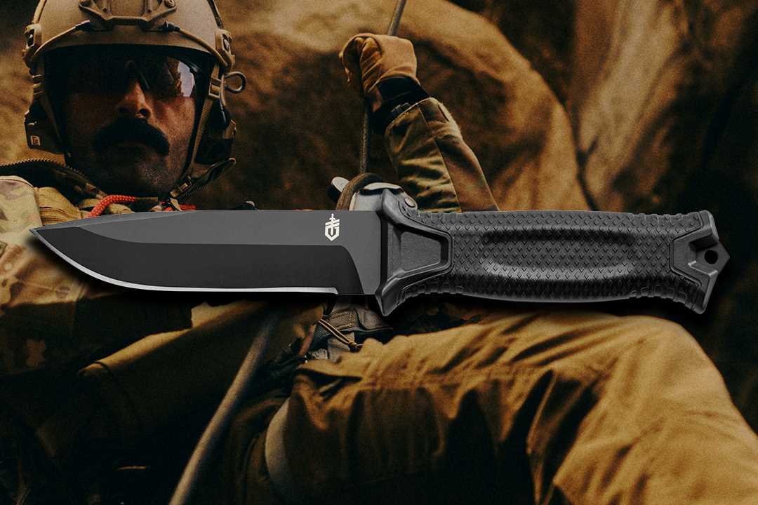 Gerber StrongArm shown in front of a soldier in combat gear, including a helmet and sunglasses, reppeling down a rock